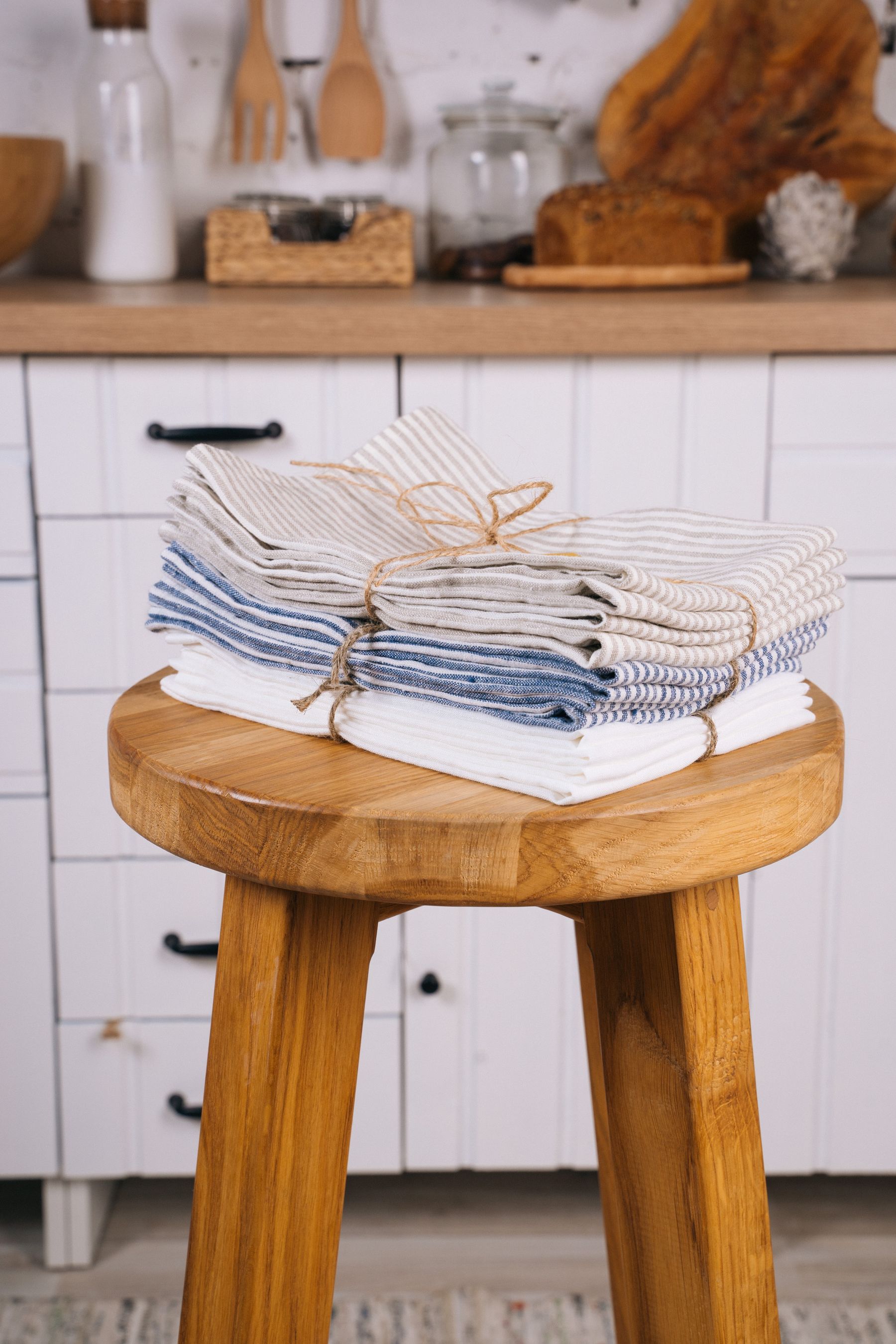 Freshly laundered linens folded and tied on a wooden stool