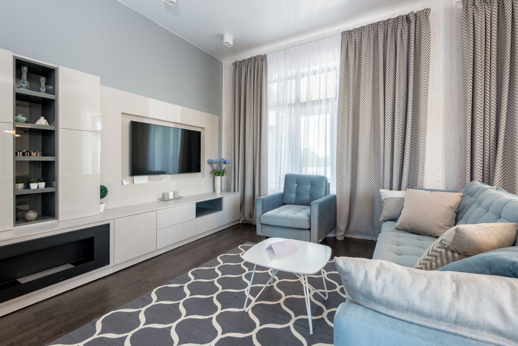 Sunlit, immaculately clean living room with white sofa and polished wooden floor